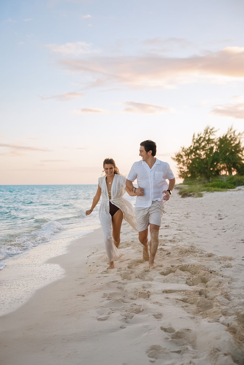 Hand in hand along the shoreline at sunset